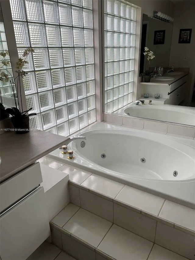 bathroom with vanity and a relaxing tiled tub