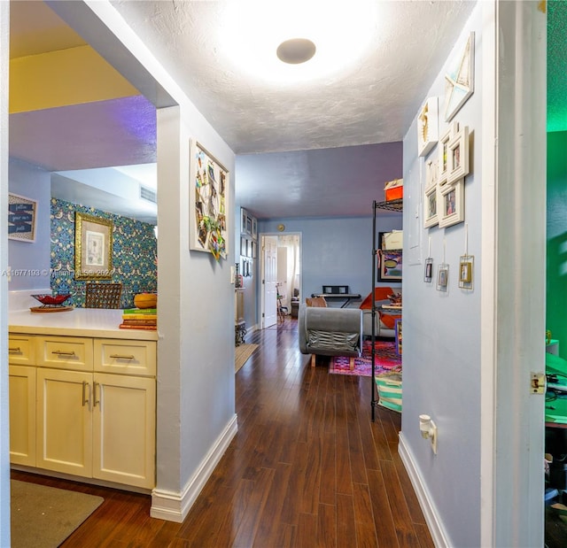 hall with a textured ceiling and dark hardwood / wood-style floors