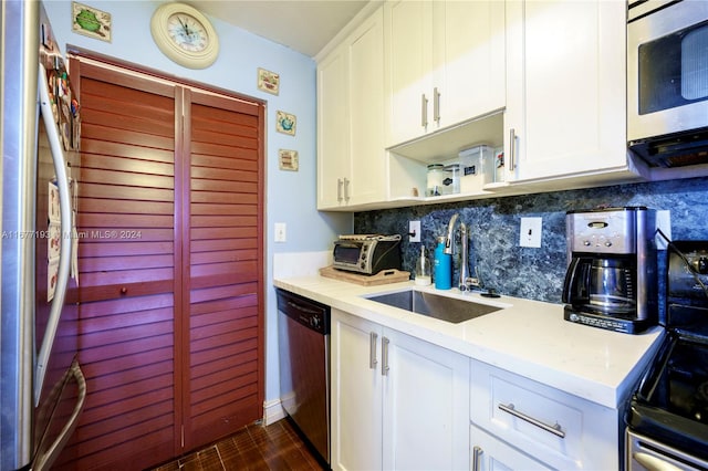 kitchen featuring backsplash, sink, appliances with stainless steel finishes, and white cabinets