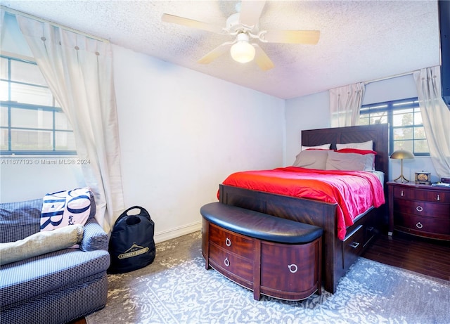 bedroom with a textured ceiling, wood-type flooring, and ceiling fan