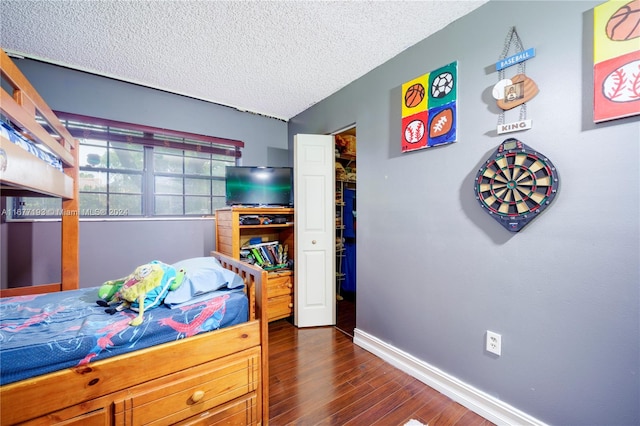 bedroom featuring a textured ceiling and dark hardwood / wood-style floors