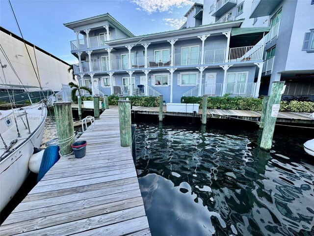 view of dock featuring a water view and a balcony