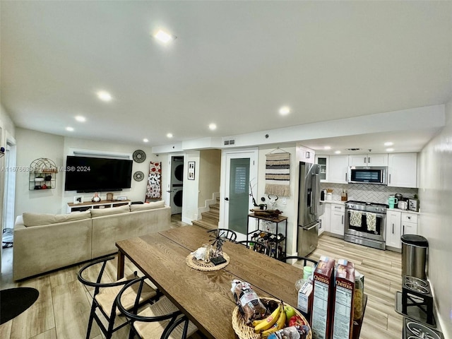 dining room featuring light hardwood / wood-style flooring and stacked washer and clothes dryer