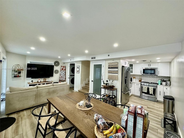 dining room featuring light hardwood / wood-style flooring and stacked washer / drying machine