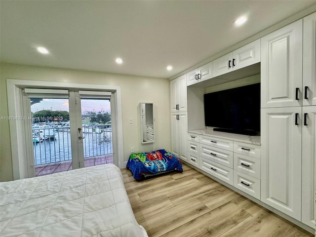 bedroom with light hardwood / wood-style floors, french doors, and access to exterior