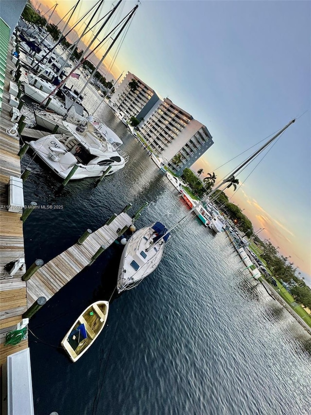 aerial view at dusk featuring a water view