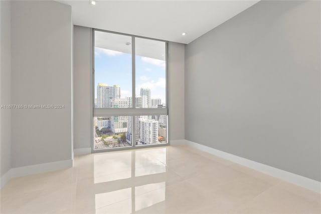 tiled spare room with a wall of windows