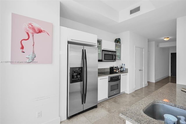 kitchen with stone counters, sink, appliances with stainless steel finishes, and white cabinets