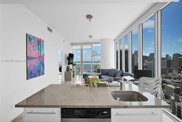 kitchen featuring sink, stone counters, dishwashing machine, and white cabinets