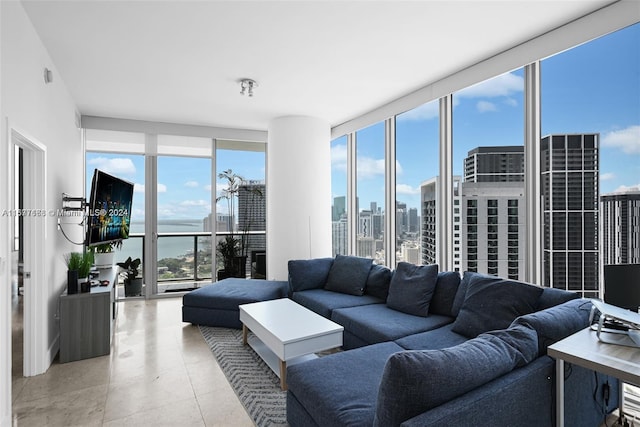 living room featuring a wall of windows, light tile patterned floors, and a wealth of natural light