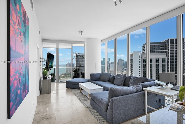 living room with light tile patterned flooring and a wall of windows