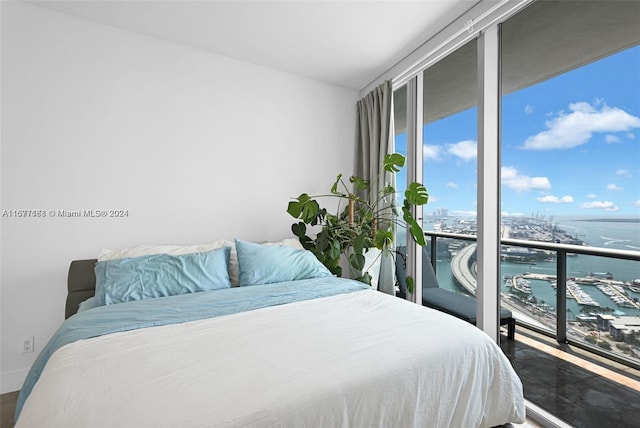 bedroom featuring a wall of windows and a water view