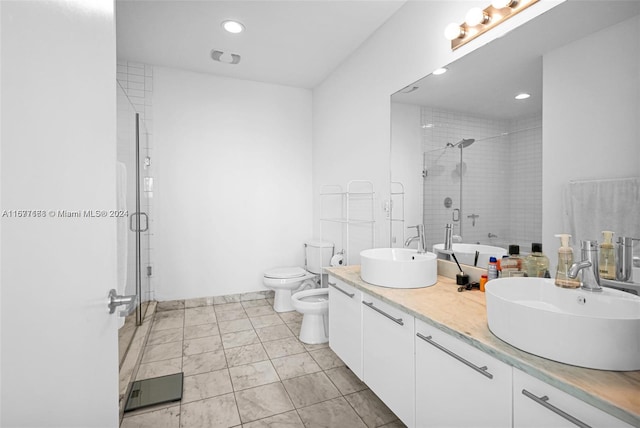 bathroom featuring a shower with door, toilet, vanity, a bidet, and tile patterned flooring