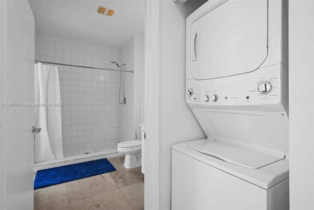 bathroom featuring stacked washer / dryer, toilet, and walk in shower