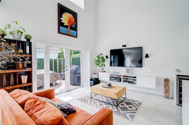 living room with wine cooler, a high ceiling, and french doors