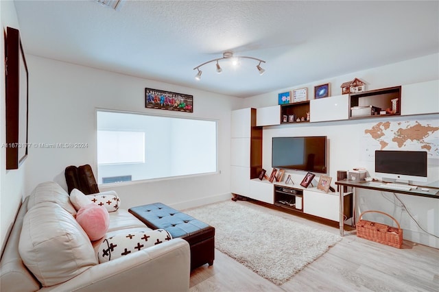 living room with light hardwood / wood-style floors and a textured ceiling