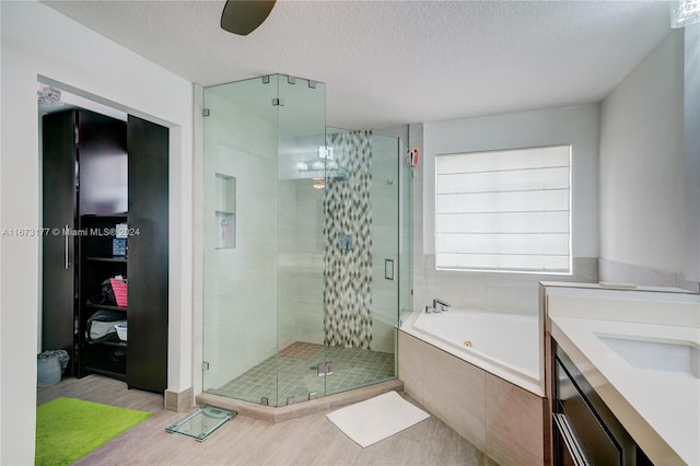 bathroom featuring plus walk in shower, a textured ceiling, and hardwood / wood-style flooring