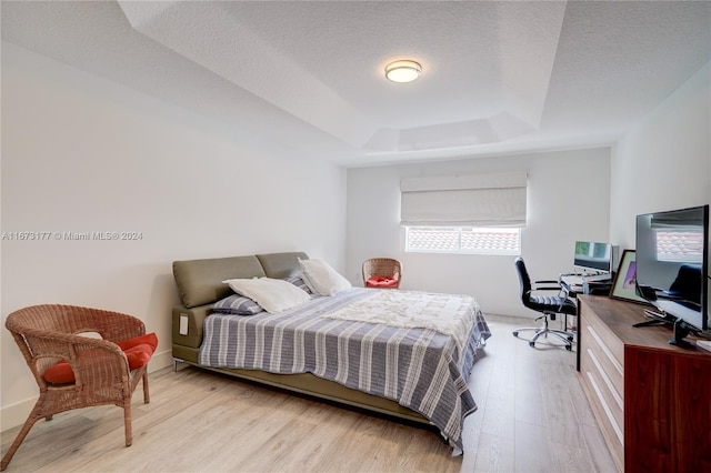 bedroom with light hardwood / wood-style floors and a textured ceiling