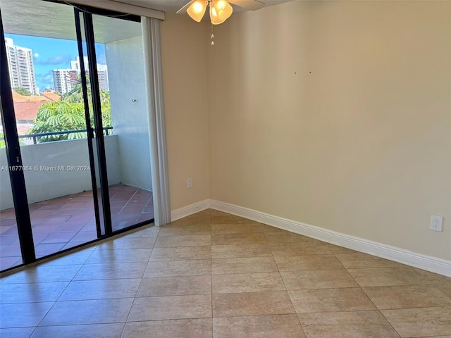 spare room featuring ceiling fan and light tile patterned floors