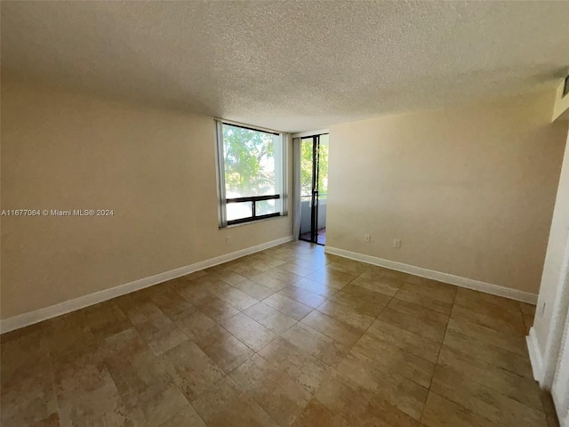 unfurnished room with a textured ceiling