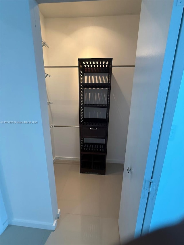 spacious closet with light tile patterned floors