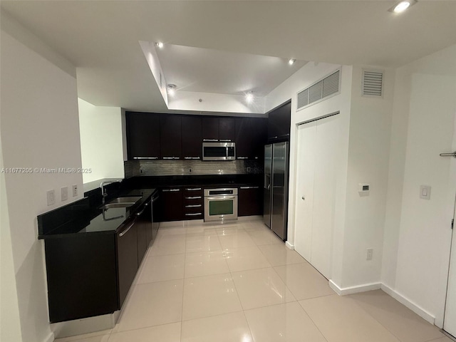 kitchen with stainless steel appliances, light tile patterned flooring, sink, and decorative backsplash