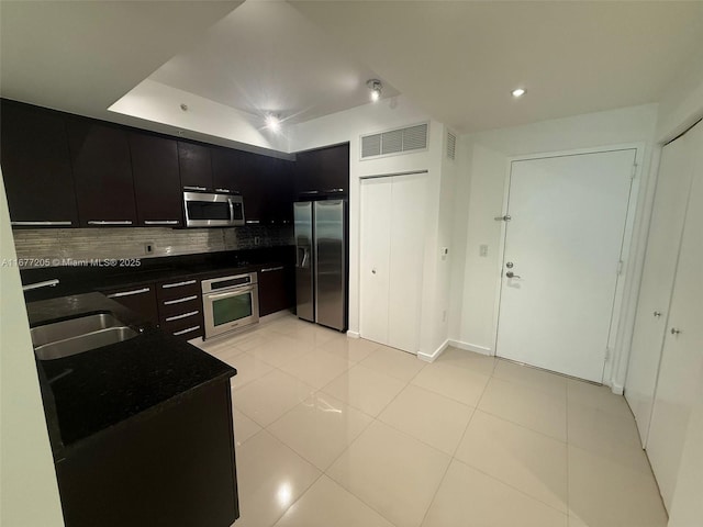 kitchen with tasteful backsplash, appliances with stainless steel finishes, sink, and light tile patterned floors