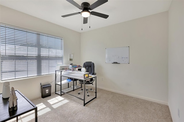 carpeted office space with ceiling fan