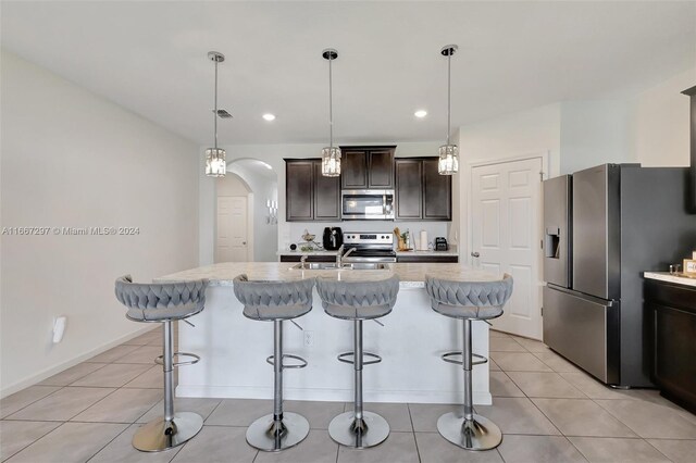 729 SW Lakehurst Dr, Port St Lucie, FL 34983 - kitchen with stainless steel appliances, a breakfast bar, dark brown cabinets, arched walkways, and a sink