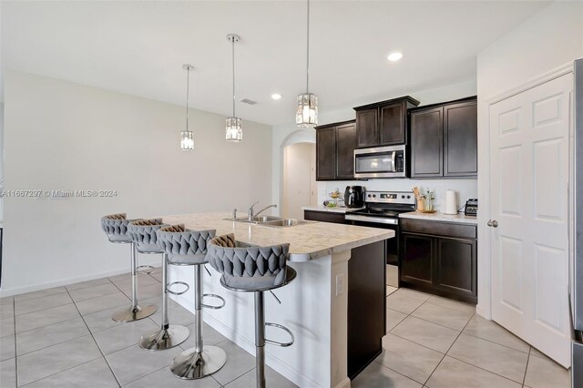 729 SW Lakehurst Dr, Port St Lucie, FL 34983 - kitchen with stainless steel appliances, a sink, arched walkways, light countertops, and a kitchen breakfast bar