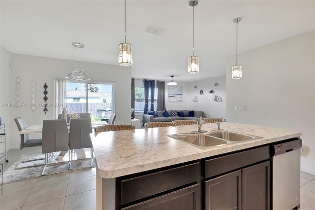 kitchen featuring sink, light tile patterned flooring, dishwasher, pendant lighting, and a kitchen island with sink