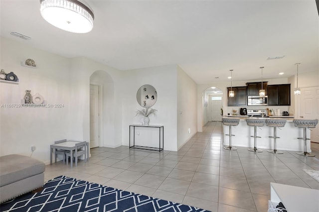 729 SW Lakehurst Dr, Port St Lucie, FL 34983 - living area with arched walkways, light tile patterned floors, and baseboards