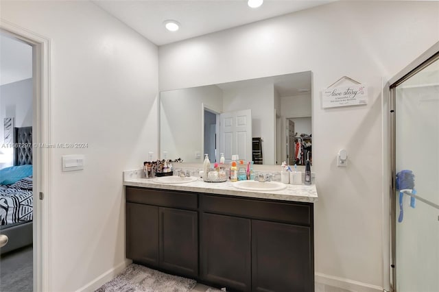 729 SW Lakehurst Dr, Port St Lucie, FL 34983 - ensuite bathroom featuring double vanity, baseboards, a spacious closet, and a shower with door