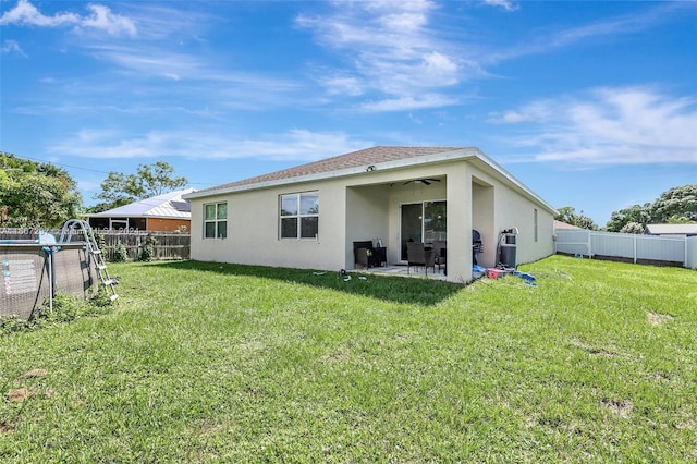 back of house featuring a patio area and a lawn