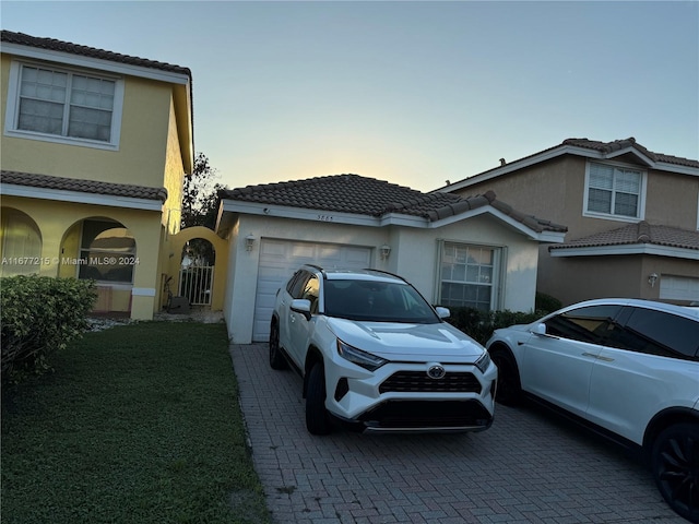 view of front of house featuring a garage and a lawn