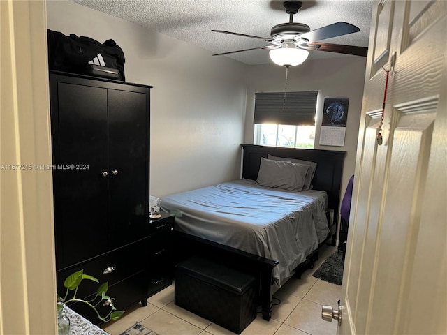 bedroom featuring ceiling fan, a textured ceiling, and light tile patterned flooring