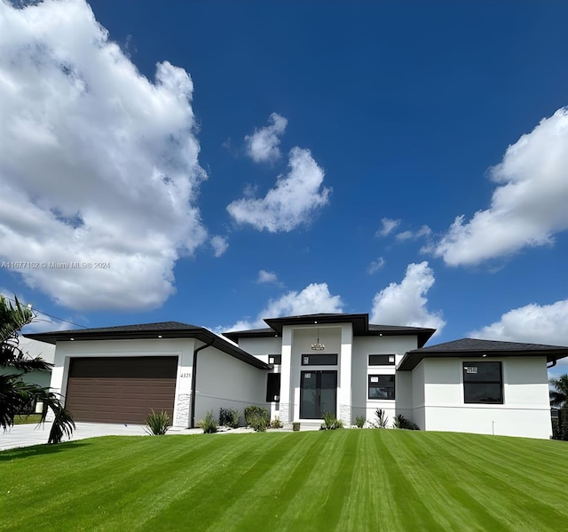 prairie-style house featuring a front lawn and a garage