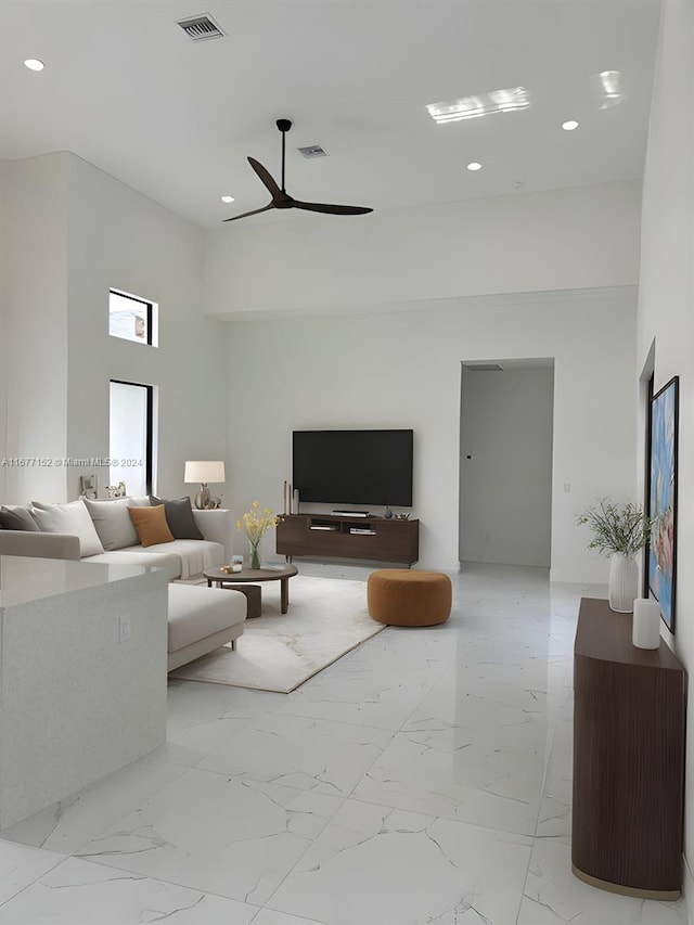 living room featuring a towering ceiling and ceiling fan