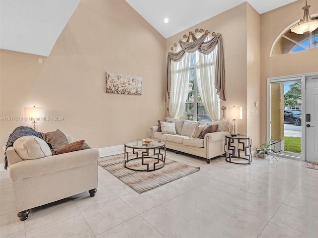 living room featuring light tile patterned flooring, high vaulted ceiling, and plenty of natural light