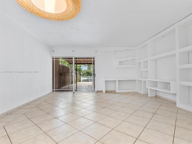 unfurnished living room featuring built in features and light tile patterned floors