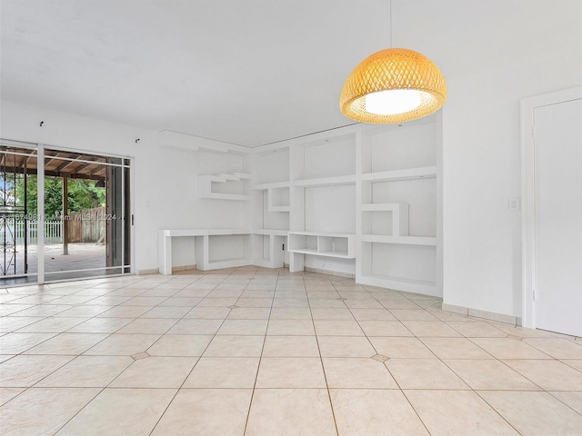 unfurnished living room with built in shelves and light tile patterned flooring