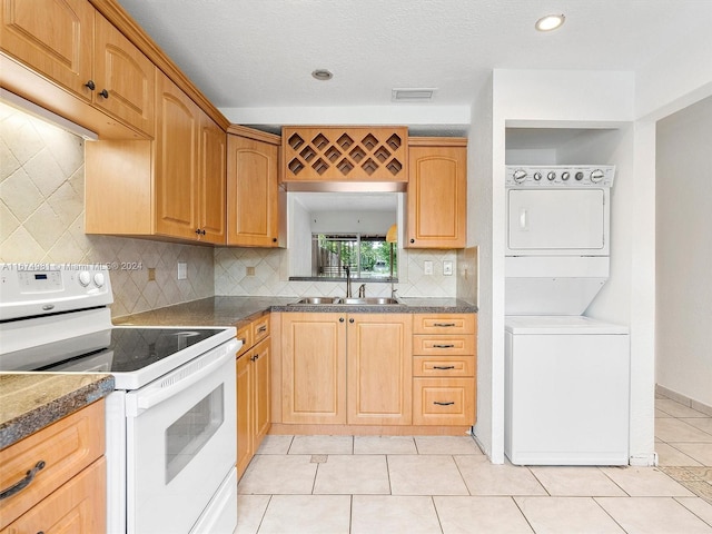 kitchen featuring white electric range oven, light tile patterned flooring, sink, stacked washer / drying machine, and decorative backsplash