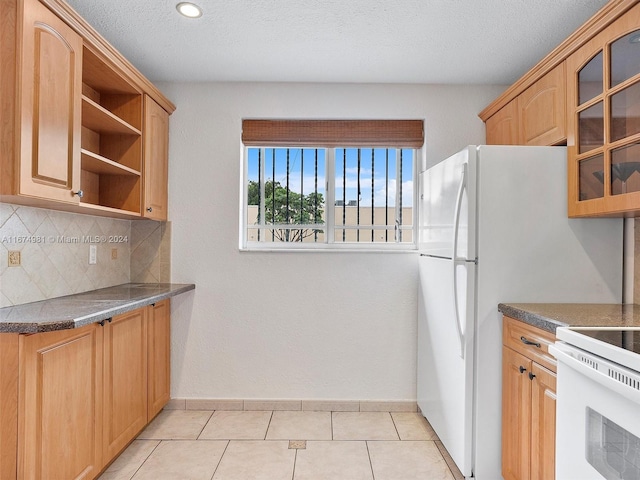 kitchen featuring tasteful backsplash, white range oven, light tile patterned floors, and a textured ceiling