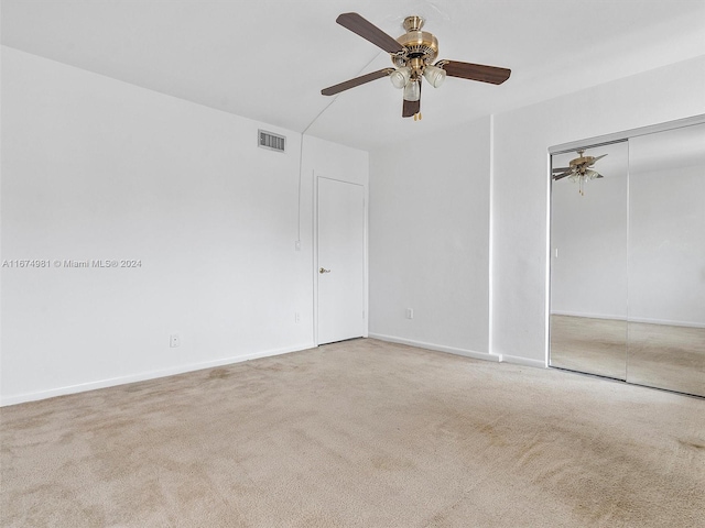 carpeted empty room featuring ceiling fan