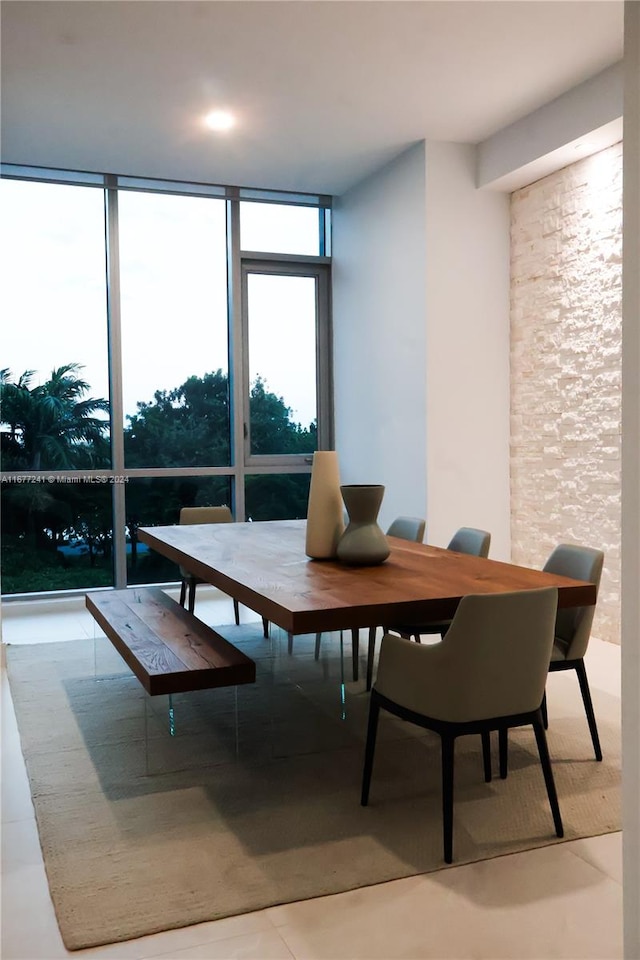 dining space with a wall of windows and tile patterned flooring