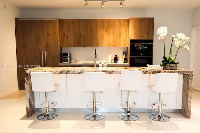 kitchen featuring sink, a breakfast bar, and double oven