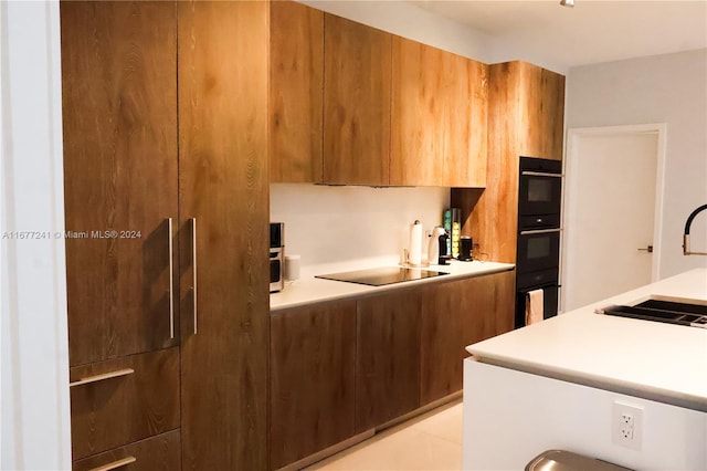 kitchen with black appliances, sink, and light tile patterned floors