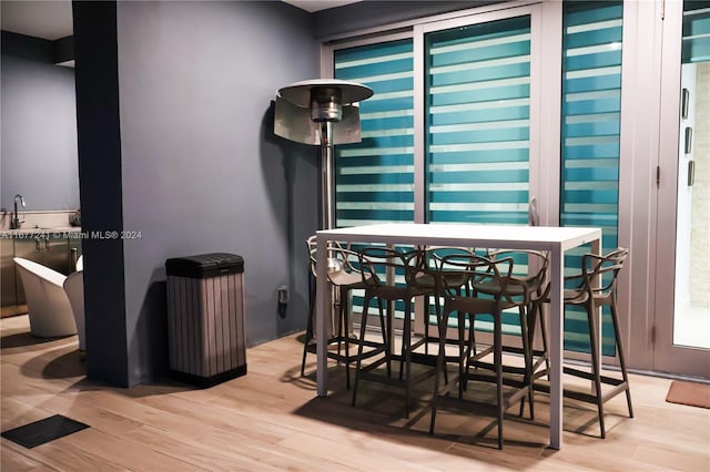 dining area with light hardwood / wood-style flooring and wet bar