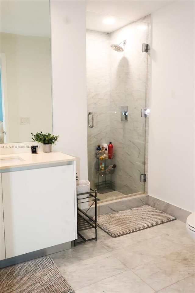 bathroom with a shower with door, vanity, and toilet