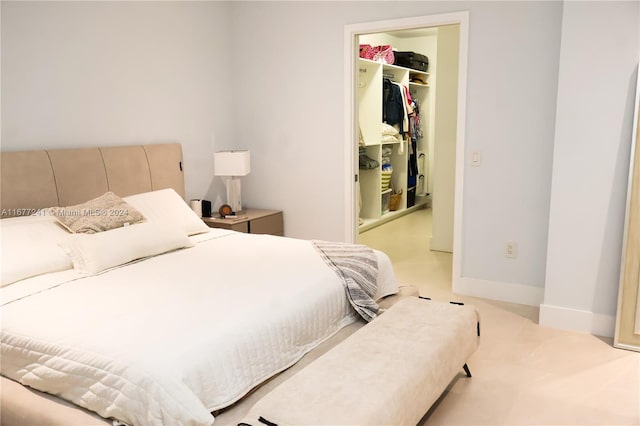 carpeted bedroom featuring a spacious closet and a closet